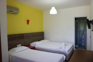 契拉勒斯姆格旅馆的一间设有三张床的客房,位于一个黄色的墙壁上