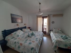 斯基亚索斯镇莫利亚酒店的一间卧室设有两张床和窗户。