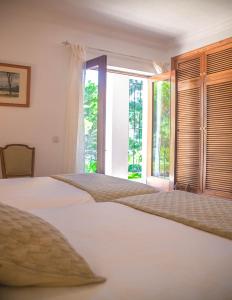 贝尼多姆Villa Altozano with pool, barbeque, large garden, and fantastic sea views的一间卧室设有两张床和开放式窗户。