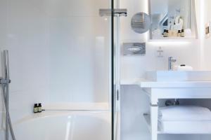巴黎波美酒店的白色的浴室设有浴缸和水槽。