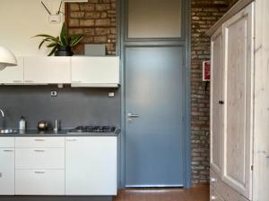 马斯特里赫特Besselaar Apartments的厨房配有白色橱柜和蓝色门