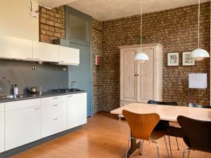 马斯特里赫特Besselaar Apartments的厨房配有白色橱柜和木桌
