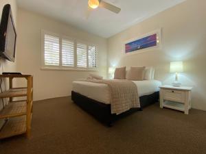 拜伦湾拜伦季公寓酒店的一间卧室设有一张大床和一个窗户。