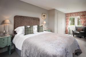 莫珀斯Throphill Grange的一间卧室配有一张大床和一把椅子