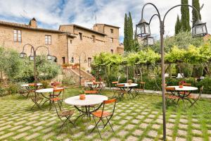 圣奎里科-多尔恰PALAZZO DEL CAPITANO Wellness & Relais - Luxury Borgo Capitano Collection的一座带桌椅的花园位于一座建筑前