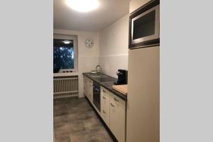 克雷费尔德Ferienwohnung Wohnung Krefeld Forstwald Höltehoffe的厨房配有水槽和微波炉