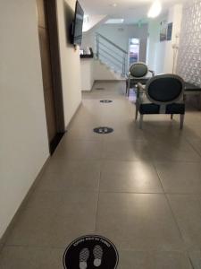 马尼萨莱斯Hotel Grato Manizales的走廊上设有两把椅子,地面上设有等候室