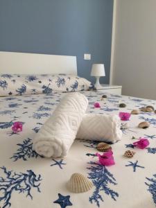 坎波马里诺B&B Campitur的床上有一条毛巾和贝壳