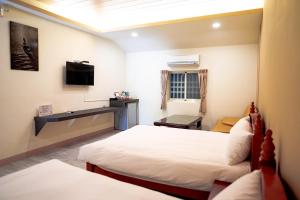 满洲乡小森园住宿的酒店客房设有两张床和电视。