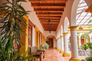 圣克里斯托瓦尔-德拉斯卡萨斯Hotel Casa Margarita的建筑中的一个拱廊,有黄色和白色的墙壁