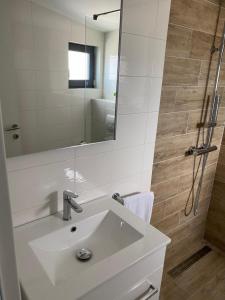 奈维斯Apartmani Bella Vista的一间带水槽、镜子和淋浴的浴室
