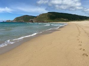 菲尼斯特雷apartamestos beach Langosteira的沙滩和海洋中的一个足迹