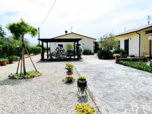 斯佩洛Residence Terra Dei Santi Country House的一个带凉亭和盆栽的花园