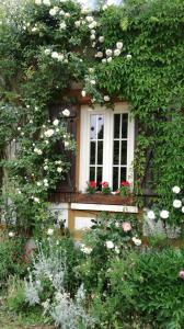 Bois-Jérôme-Saint-Ouen森林农场酒店的建筑前有鲜花的窗户