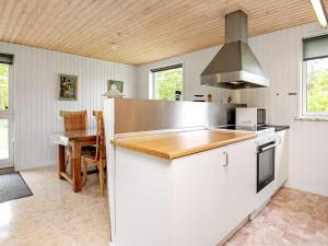 乌尔夫堡6 person holiday home in Ulfborg的厨房配有白色橱柜和炉灶烤箱。