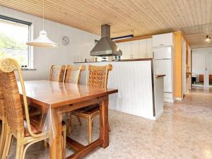 乌尔夫堡6 person holiday home in Ulfborg的厨房配有木桌和一些椅子