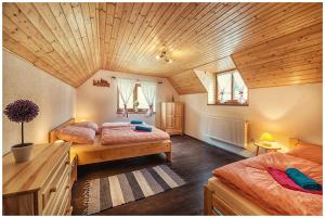 DúbravaChata Margitka的一间卧室设有两张床和木制天花板
