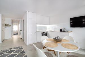 巴塞罗那Comtal homey apartments的白色的厨房配有白色的桌子和椅子