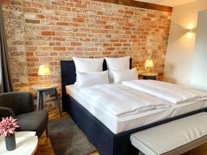 吕讷堡Wyndberg的一间卧室设有一张带砖墙的大床