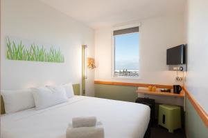 奥克兰奥克兰机场宜必思快捷酒店的酒店客房设有白色的床和窗户。