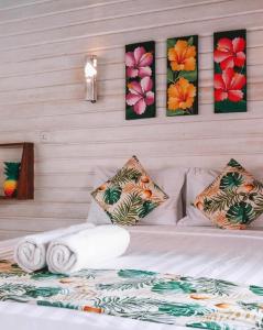 吉利特拉旺安Voodoo Gili的一间卧室配有一张带毛巾和壁画的床。