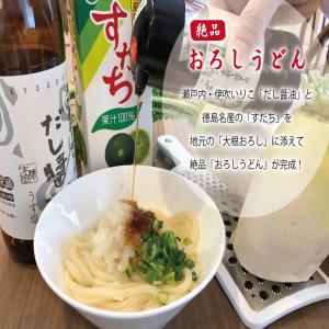 丸龟市Super Hotel Marugame Ekimae的一瓶葡萄酒和一碗面条