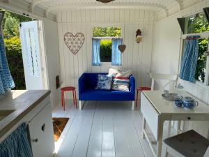 东福尔讷Little blue house (on the campsite)的客厅配有蓝色的沙发和桌子