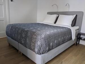赞德沃特Beachtime Suite的一张带灰色棉被和白色枕头的床