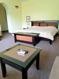 萨拉他蒙蒂鲁Hotel Monteoru的酒店客房,配有床、桌子和床筒。