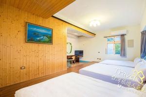 绿岛绿岛蓝海奇缘民宿的一间卧室配有两张床和一张书桌