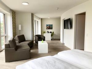 布伦瑞克ADAPT Apartments Braunschweig的一间卧室配有一张床、一张沙发和椅子