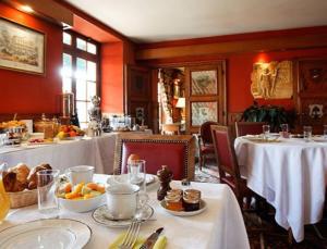 枫丹白露德隆德里斯酒店的一间用餐室,配有2张桌子、白色桌布和食物