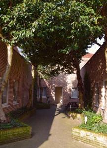 鲁汶Condo Gardens Leuven - Large One Bedroom的前面有树的砖砌建筑