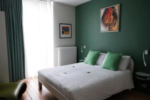 奥斯坦德Villa Les Paquerettes的一间卧室设有一张带绿色墙壁的大床