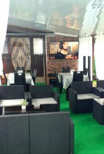 OpanetsGuest Rooms Simona的一间设有绿色地板和桌椅的餐厅