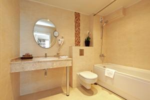 巴尔奇克白岩城堡套房酒店及SPA的浴室配有盥洗盆、卫生间和浴缸。