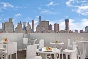纽约温德姆花园唐人街酒店的一个带桌椅的屋顶露台,享有城市天际线
