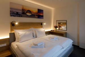 StachySporthotel Olympia的卧室配有白色的床和2条毛巾