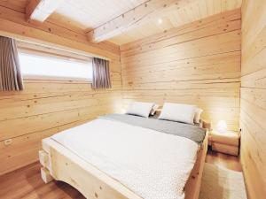 拉多夫吉卡Log House Natura的木制客房内的一间卧室,配有一张床