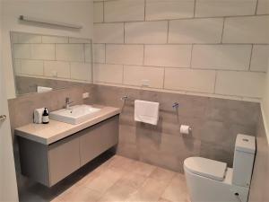 坎贝尔港中港4号公寓的一间带水槽、卫生间和镜子的浴室