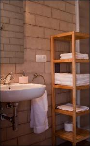 阿尔巴拉辛巴莱纳公寓的浴室设有水槽和带毛巾的架子。
