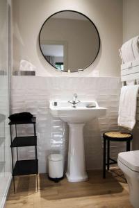 多维尔Les Manoirs des Portes de Deauville - Small Luxury Hotel Of The World的白色的浴室设有水槽和镜子