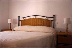 阿尔巴拉辛巴莱纳公寓的一间卧室配有一张大床和两盏灯