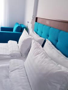 苏利纳Helios的白色的床、白色枕头和蓝色沙发