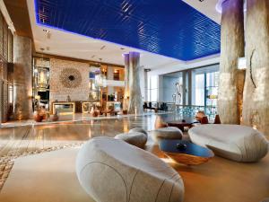 索维拉索维拉莫加多尔索菲特高尔夫酒店及水疗中心的大堂设有桌椅和蓝色天花板。