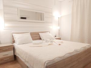 亚德里亚Apartments Adria的卧室配有白色的床和毛巾