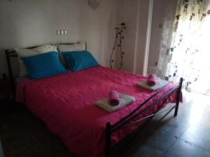 卢特拉艾季普苏Nikos Rooms的一间卧室配有带粉红色床单和2条毛巾的床