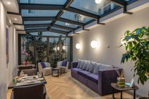 卢卡迪品脱广场酒店的客厅配有紫色的沙发和桌子
