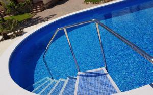 霍斯皮塔勒·德尔英福Beach Resort La Margarita的蓝色的游泳池,里面设有楼梯