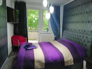 科沃布热格Apartament Nadmorski的带窗户的客房内的紫色和白色床